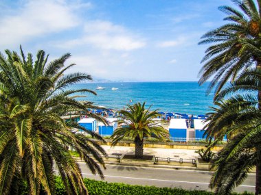 Otelin balkonundan palmiye ağaçlarının bulunduğu Akdeniz plajına bakabilirsiniz. Arenzano Liguria İtalya.