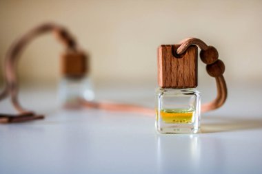 Aromatik sıvı ile küçük şişe. Bulanık arka plan ile beyaz masada Araba hava spreyi.