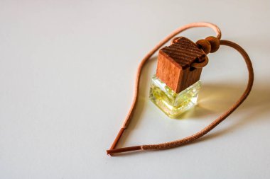Beyaz arka plan üzerinde aromatik sıvı ile küçük şişe. Ahşap kapaklı cam şişede araba hava spreyi.