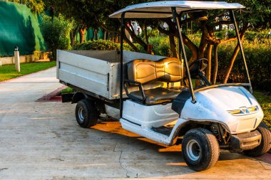 Sokaktaki golf arabası. Kısa bir yolculuk için uygun kargo bagajlı elektrikli golf arabası, insanları taşımak, parçaları ve ekipmanları taşımak.