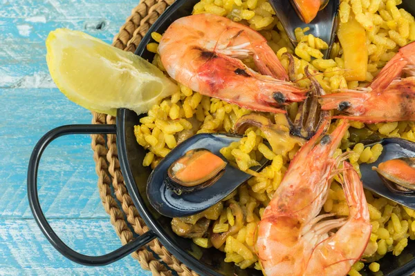 Paella mixed with lemon, cereal bread and white wine. Contains mussels, squid, prawns, chicken, peppers, peas
