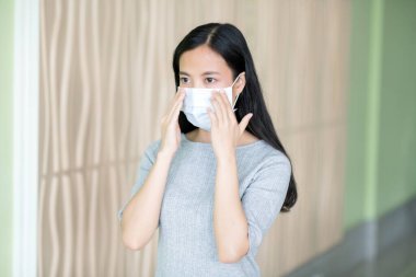 Grip maskeli Asyalı genç bir kadın.