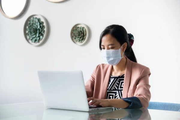 Asian young woman with laptop in office