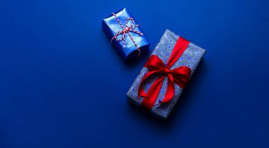 Mavi arkaplanlı kırmızı kurdeleli hediye kutusu