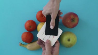 Kadın taze meyve satın alır ve satın alma kartı için öder