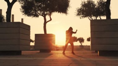 Güçlü adam mücadelede yöntemleri çalışır. Adam sokakta eğitim sırasında vücut kasları yoğurir. Hava açık hava eğitimi için uygundur. Adam farklı bir şok uyguluyor.