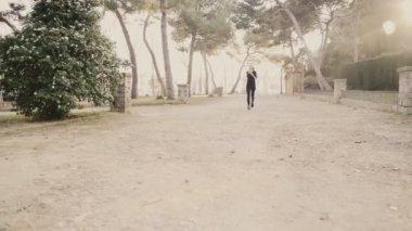 Genç bir kadın parkta merdivenlerden yukarı koşuyor. Kaçak bir kız. Hava güneşli ve sıcak. Genç bir kız güzel bir şehir parkında spor yaparken merdivenleri koşarak çıkıyor.