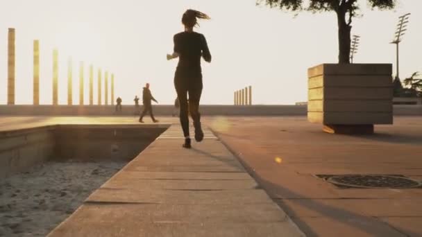 Jong meisje bereidt zich voor om te rennen in het park in de zomer, zware levensstijl, sport conceptie. Vrouw rent op de weg bij mooi weer. Vrouw is bezig met sport in de frisse lucht. — Stockvideo
