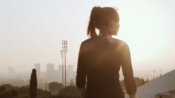 Meisje doet oefeningen in het Park. Vrouw die betrokken is bij sport. Geschiktheid voor gezondheid. Het meisje strekt zich uit de spieren van haar handen. Vrouw versterkt de spieren van de rug. — Stockvideo