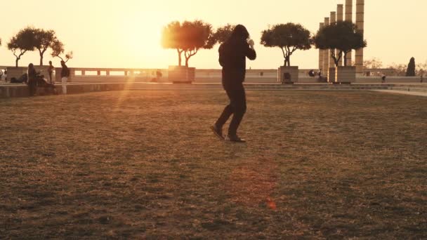 El hombre fuerte entrena tipos de golpes. Guy amasa los músculos de las piernas y los brazos durante el entrenamiento en la calle.El clima es adecuado para el entrenamiento al aire libre. El hombre entrena técnicas básicas de lucha — Vídeo de stock