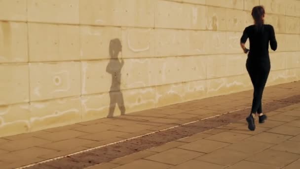 Girl on the run. The weather is Sunny and warm. A young girl runs up the stairs during a running workout. — Stock Video