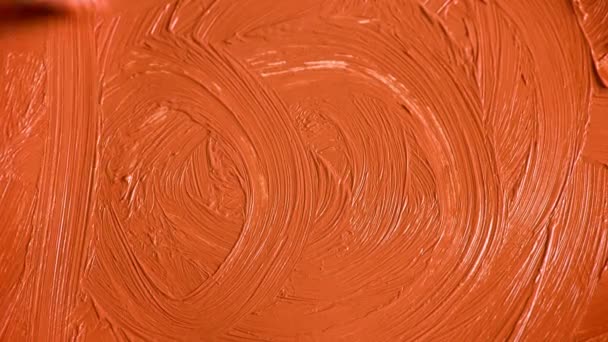 El artista aplica una gruesa capa de pintura naranja. Pintura acrílica. Patrón de color. El artista unta una densa capa de acrílico sobre el lienzo con un pincel. Textura acrílica. Trazos sobre lienzo . — Vídeos de Stock