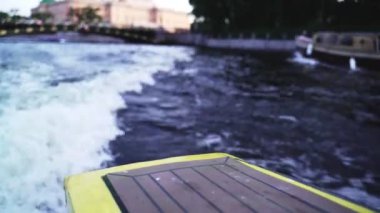 Nehirden geçen sarı bir tekneye yaklaşıyoruz. Su köpüğü ve dalgalar, hız, yaz macerası rüzgarı. Saint Petersburg 'da nehir ve kanallar geziyor. Seyahat ve tatil, yat, tekne gezisi..