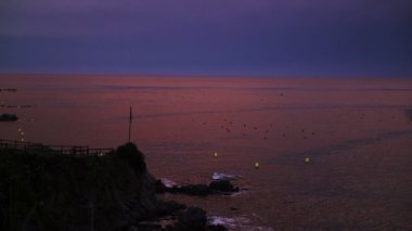 Akdeniz kıyısında küçük bir kasabada güzel bir gün batımı. Violet ve pembe gökyüzü ve mor deniz. Sahildeki beyaz evler. Huzur ve sessizlik. Gün batımında pembe bulutlar. Denizde tatiller