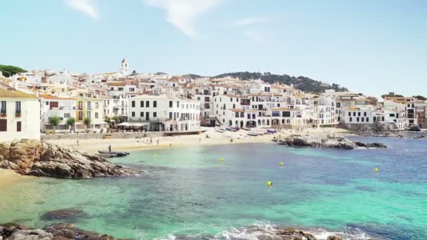 Gyönyörű kilátás nyílik egy kis mediterrán város. A falu a lenyűgöző smaragd öböl partján van. Napsütéses nyári nap a tenger mellett. Nyaralás a parton. Festői fehér házak a homokos tengerparton. — Stock videók