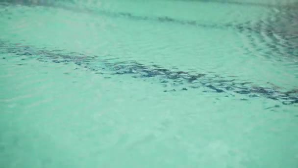 Água limpa da piscina. Água doce turquesa na piscina em um dia quente. Ondas de luz na superfície da água. Férias de verão. Frescura e frescura num dia ensolarado. O jogo de luz em ondulações de água . — Vídeo de Stock