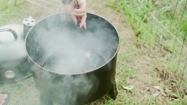 Arkadaşlarla yaz barbeküsü. Aşçı taşınabilir bir barbeküde fırında patates ve tatlı patates hazırlar. Lezzetli yemekler. Açık hava yemeği.. 