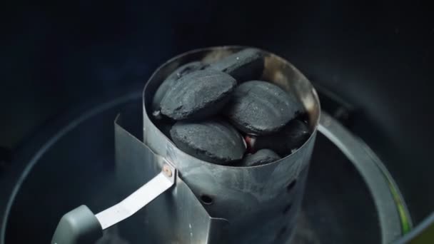 BBQ s přáteli na zahradě. Detailní záběr na dřevěné uhlí u domácího kuřáka. Lehké uhlí na grilování. Kouřící dřevěné uhlí v přenosném grilu. — Stock video