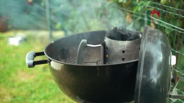 BBQ with friends in the garden. Close-up of charcoal in a home smoker. Lighter coal for barbecue. Steaming charcoal in a portable barbecue. — Stock Video