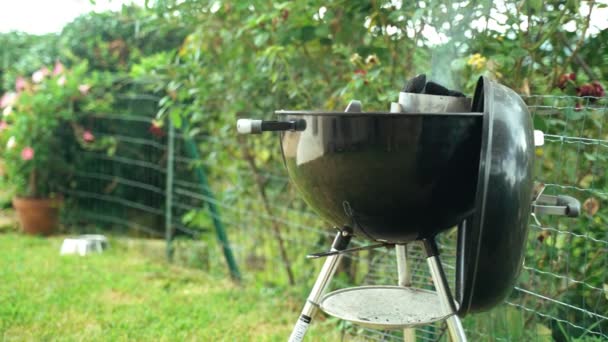 BBQ з друзями в саду. Виготовлення деревного вугілля у домашньому курцеві. Світле вугілля для барбекю. Паркування вугілля на переносному барбекю.. — стокове відео