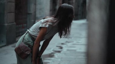 Güzel, uzun saçlı esmer kız güzel şehirde dolaşıyor. Genç ve çekici bir kadın ortaçağ kasabasının taştan sokaklarında yürüyor ve pencereye bakıyor. Etrafı gezen güzel bir turist. Gösterge