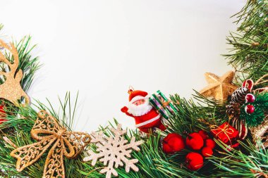 Noel Baba, çam dalları, kırmızı böğürtlen ve altın yay, beyaz arka planda kar tanesi. Noel arkaplanı. Boşluğu kopyala.