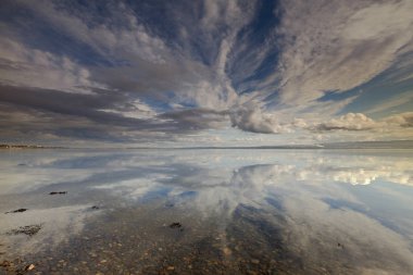 The North Sea at Cromarty on the Black Isle can be very calm on a windless day with the most fantastic cloud reflections on the huge waterscape. clipart