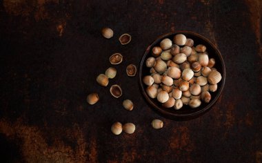 Paslı metal arka planda bir tabakta bir grup fındık. Üst görünüm.