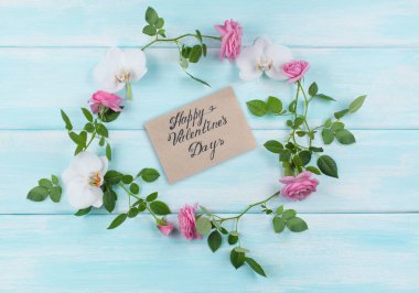 Üst çerçeve çiçek görünümünü güller ve orkide çiçekler ve tebrik kartı Sevgililer günü için shabby chic tarzı ahşap arka plan üzerinde oluşur