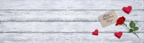 Top view of Valentines day card with velvet hearts, red rose on background of shabby wooden planks and copy space for text