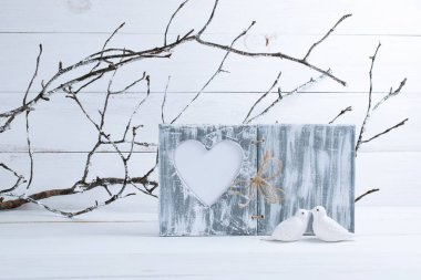 İki beyaz öpüşme güvercinler kuş şube ile kalp mockup eski püskü şık tarzda hoarfrost ve fotoğraf çerçeve ile kaplı zemin üzerine porselen biblo ile Sevgililer günü için ev iç dekor