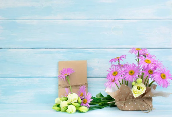 Camomille et fleurs roses et boîte cadeau sur fond en bois — Photo