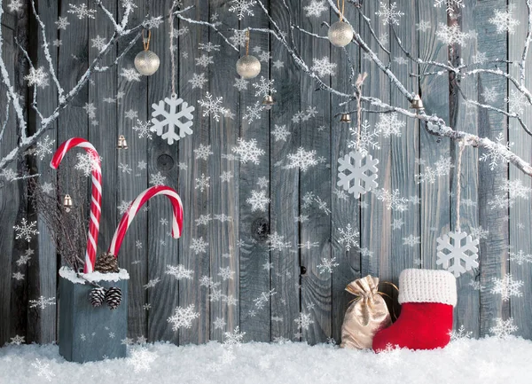 Intérieur de Noël avec branches décoratives, botte Santa, sac cadeau et boules sur fond de planches en bois — Photo