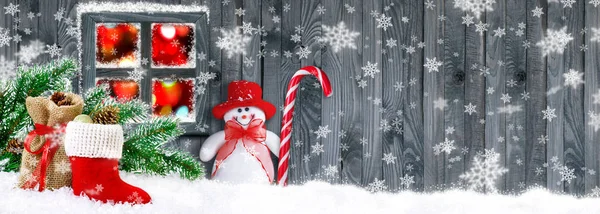 Santa bota com presentes e boneco de neve no fundo da parede de madeira — Fotografia de Stock