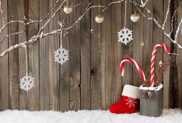 Vánoční interiér s ozdobnými větvemi, Santa bota a bonbony na dřevěných hobkáčních podkladech — Stock fotografie