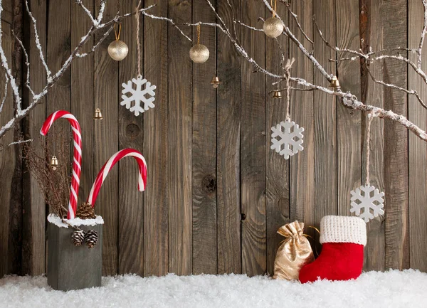 Interno natalizio con rami decorativi, stivale Babbo Natale, sacchetto regalo e bastoncini di zucchero — Foto Stock