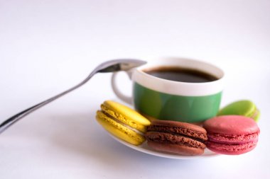 Renkli badem kurabiyeleri ve bir fincan kahve.