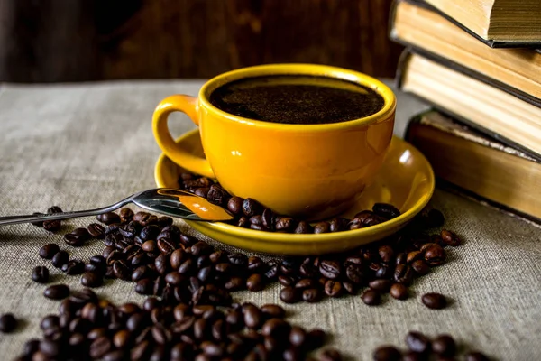 Tahta masada bir fincan kahve ve fasulye.