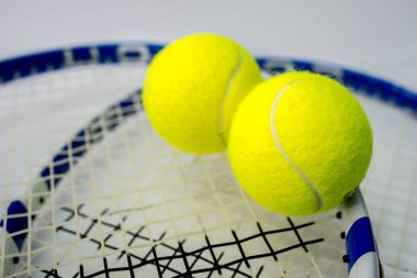 Beyaz arka planda tenis topu ve raket