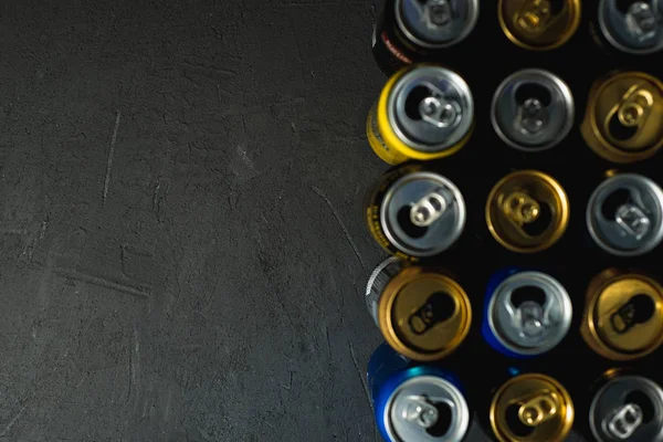 Siyah arka planda renkli boş bira kutuları