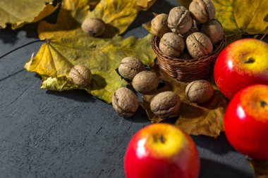 Karanlık bir sonbahar arka planında elmalar ve fındıklar