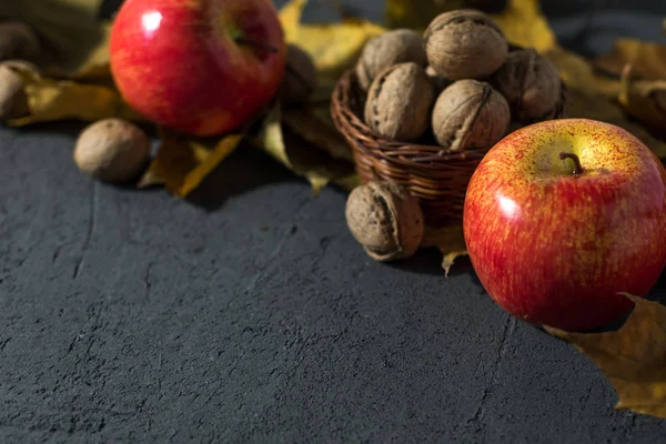 Äpfel Und Nüsse Vor Dunklem Herbsthintergrund — Stockfoto