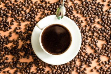 Tahta masada bir fincan kahve ve fasulye.