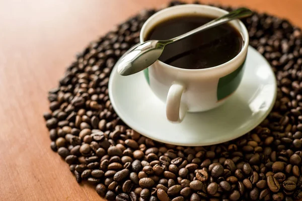 cup of coffee and beans on wooden table