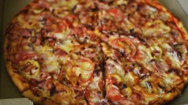 Bir kızın eli İtalyan büyük lezzetli pizzasından bir parça alır.