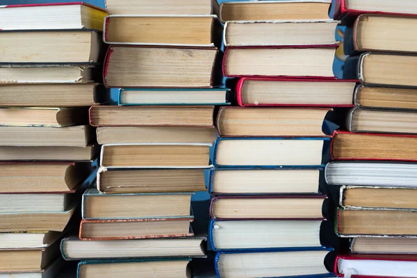 Kitap yığını arka plan. Bir sürü kitap. Kütüphanede bir yığın farklı kalınlıkta kitap, bir yığın eski kitap, okula dönüş.