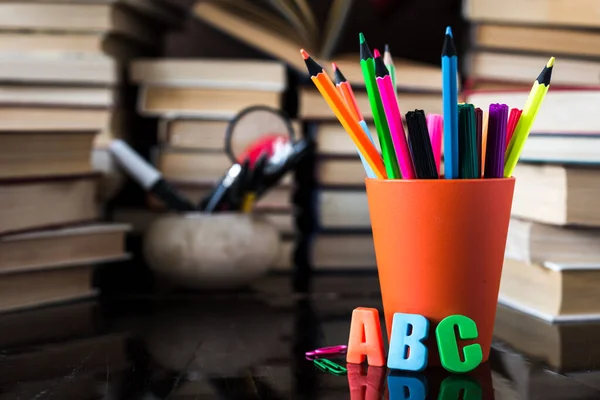 A stack of books and pencils on a desk in elementary school. A stack of colorful books. Education background. Business education concept. Copy space for text.