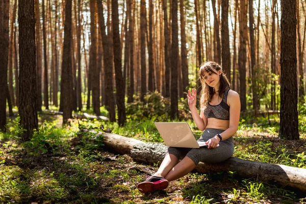 Remote communication and work in nature. Girl does business with online technologies outside. The concept of distance learning electronic gadgets.