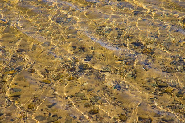 Przezroczysta Powierzchnia Wody Zmarszczki Przez Które Piaszczysty Dół Kamyczki Jest — Zdjęcie stockowe