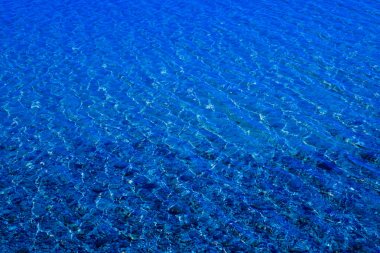 Çakıl taşlı kumlu alt görünür olduğu dalgalanmalar ile mavi su yüzeyi